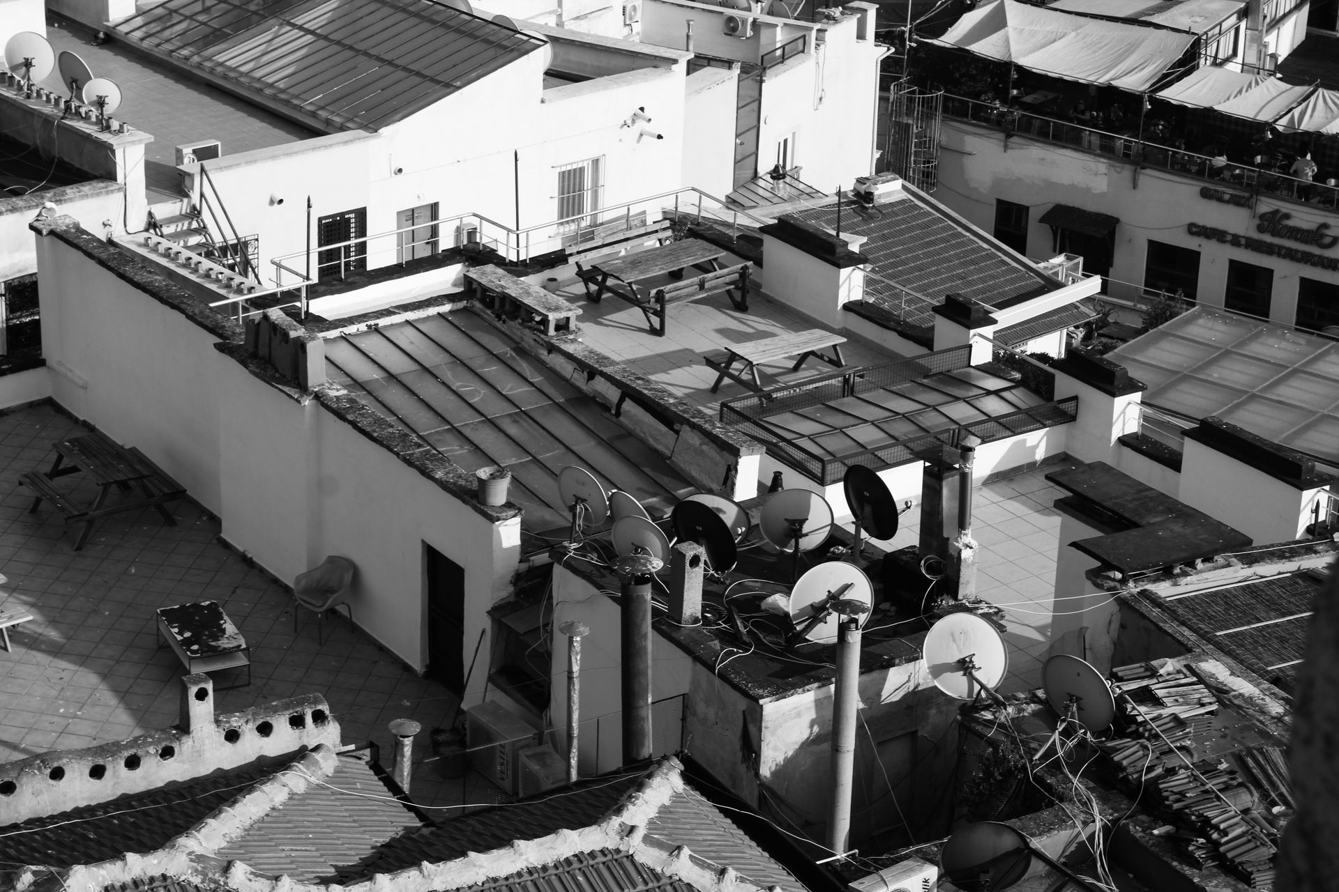 Aerial view of urban rooftops with satellite dishes, perfect for showcasing city life.