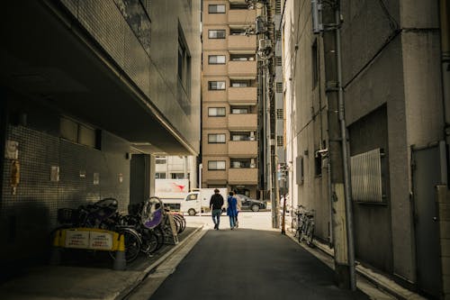 People Walking in Alley between Buildings in City Downtown