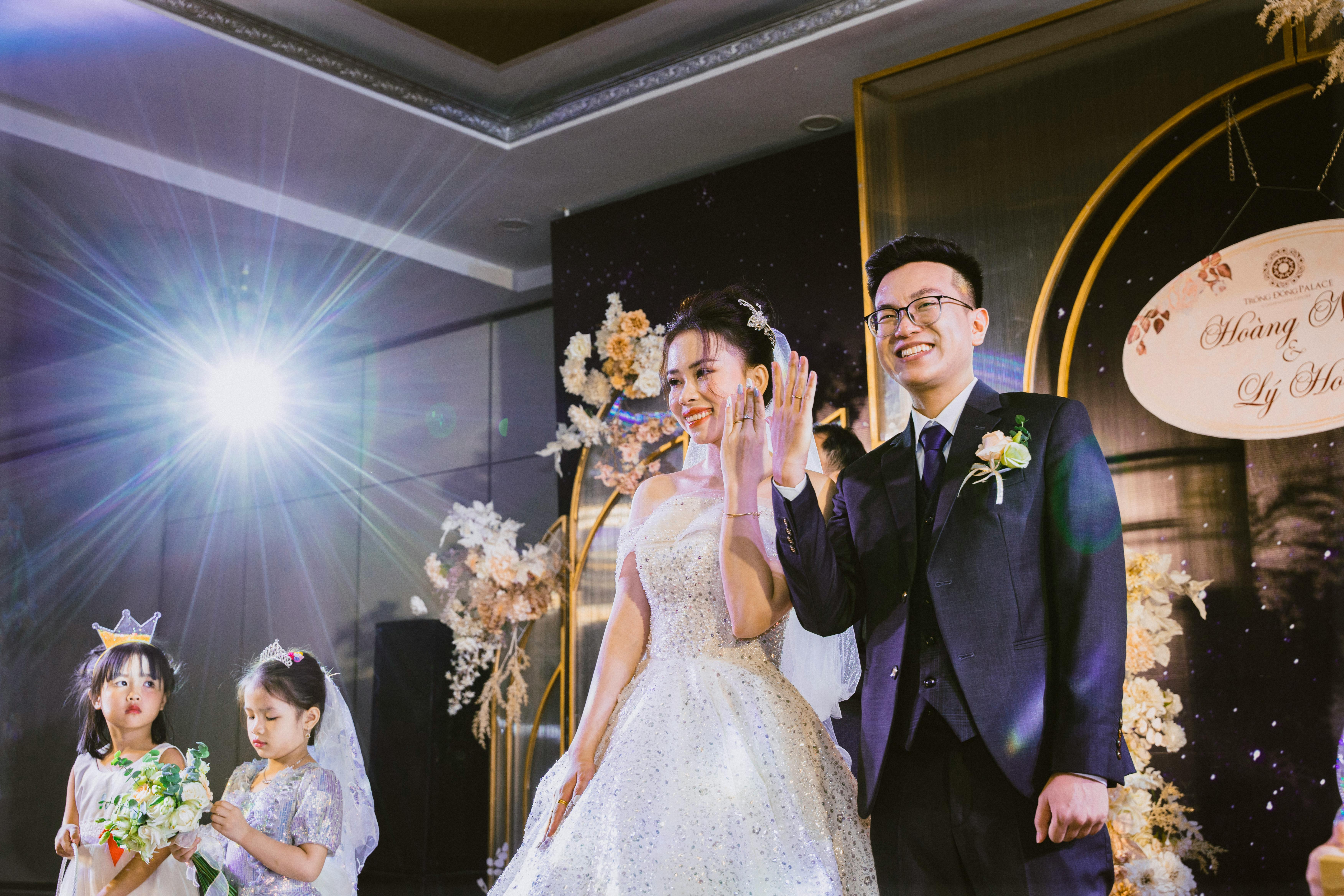 Elegant wedding ceremony featuring a bride and groom smiling, surrounded by flower girls.