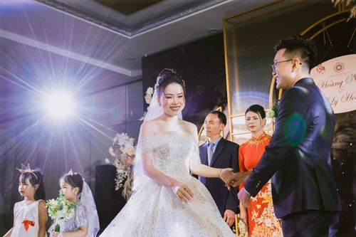 Free Joyful bride and groom holding hands during an elegant wedding ceremony indoors. Stock Photo