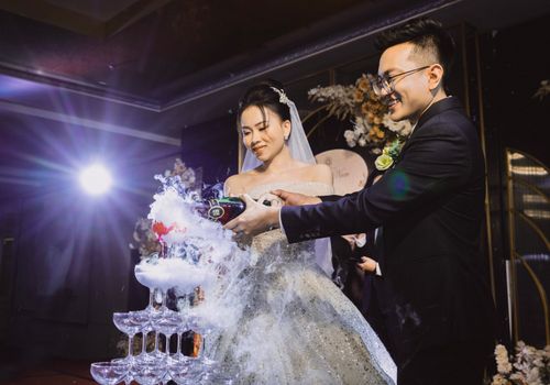 Free Bride and groom joyfully pouring champagne at their wedding ceremony. Stock Photo