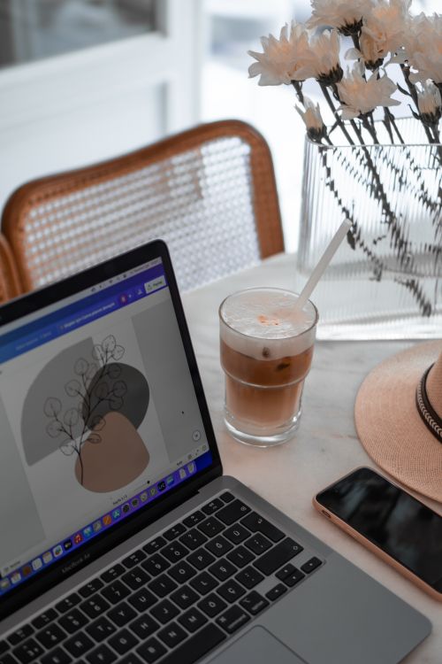 Free A stylish home office setup with a laptop, iced coffee, and neutral decor. Stock Photo