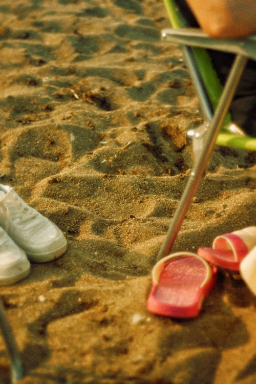 Foto profissional grátis de areia, cadeira de turista, chinelos vermelhos