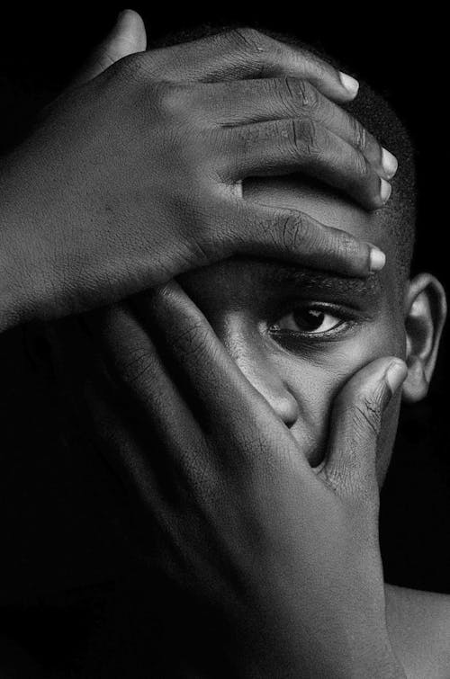 Black and White Portrait of a Man Covering his Face with Hands