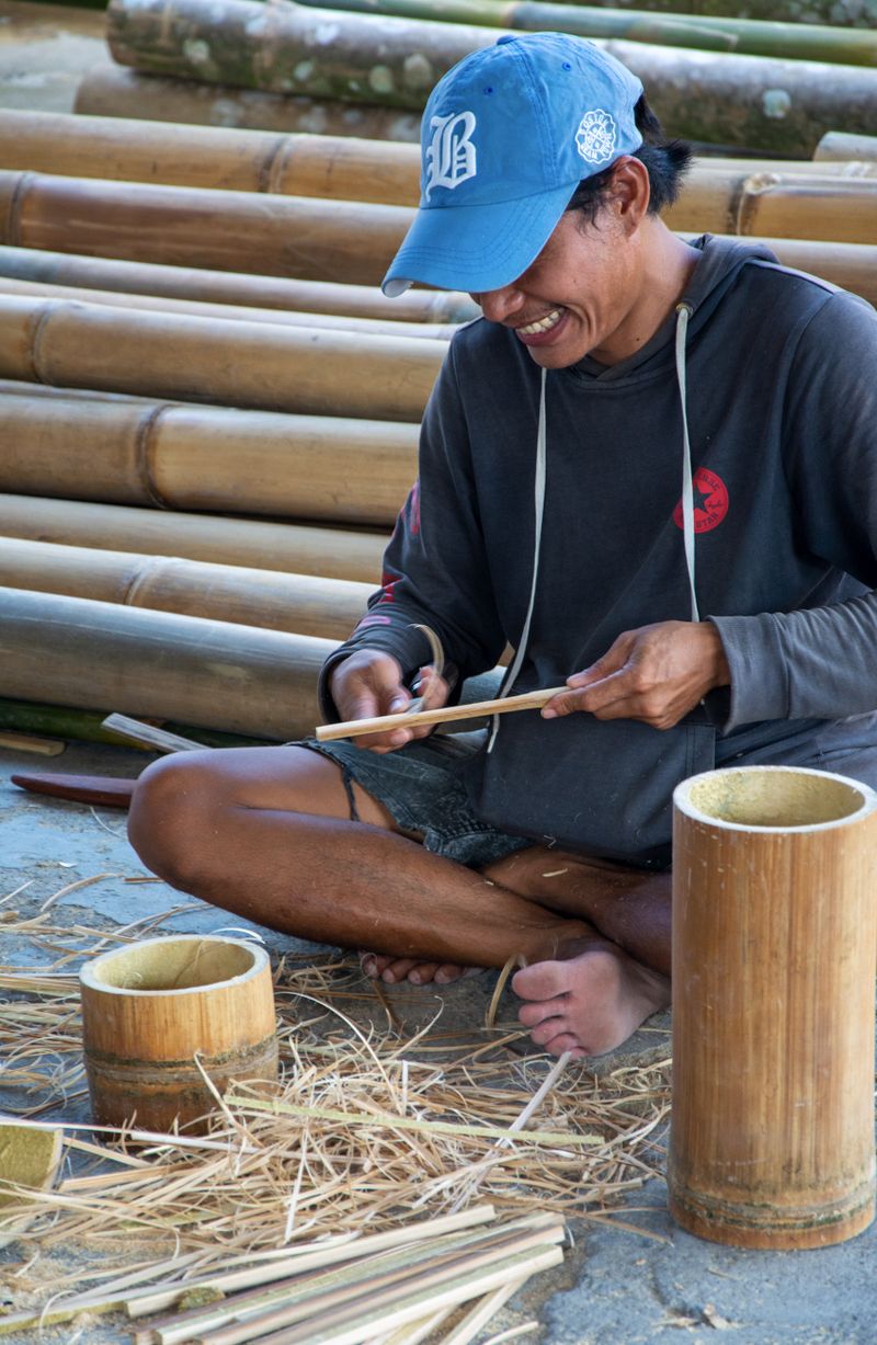 Pengrajin bambu tersenyum saat membuat kerajinan tradisional