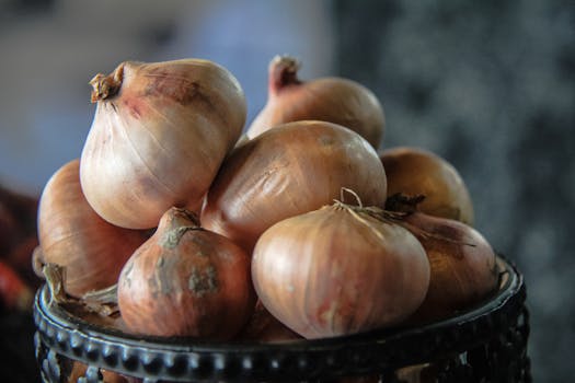 A detailed close-up view of fresh onions artfully stacked at a market in Dhaka, Bangladesh.