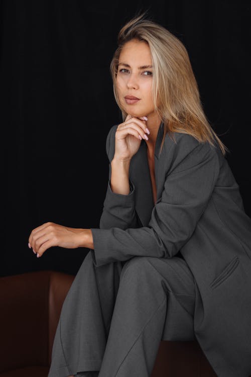 Blonde Woman Sitting in Gray Suit