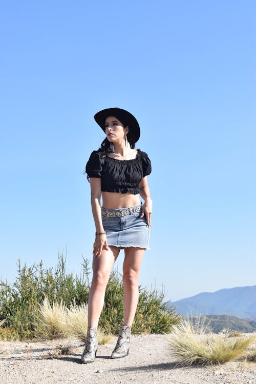 Woman Posing in Cowboy Hat, Ruffled Cropped Blouse and Denim Mini Skirt