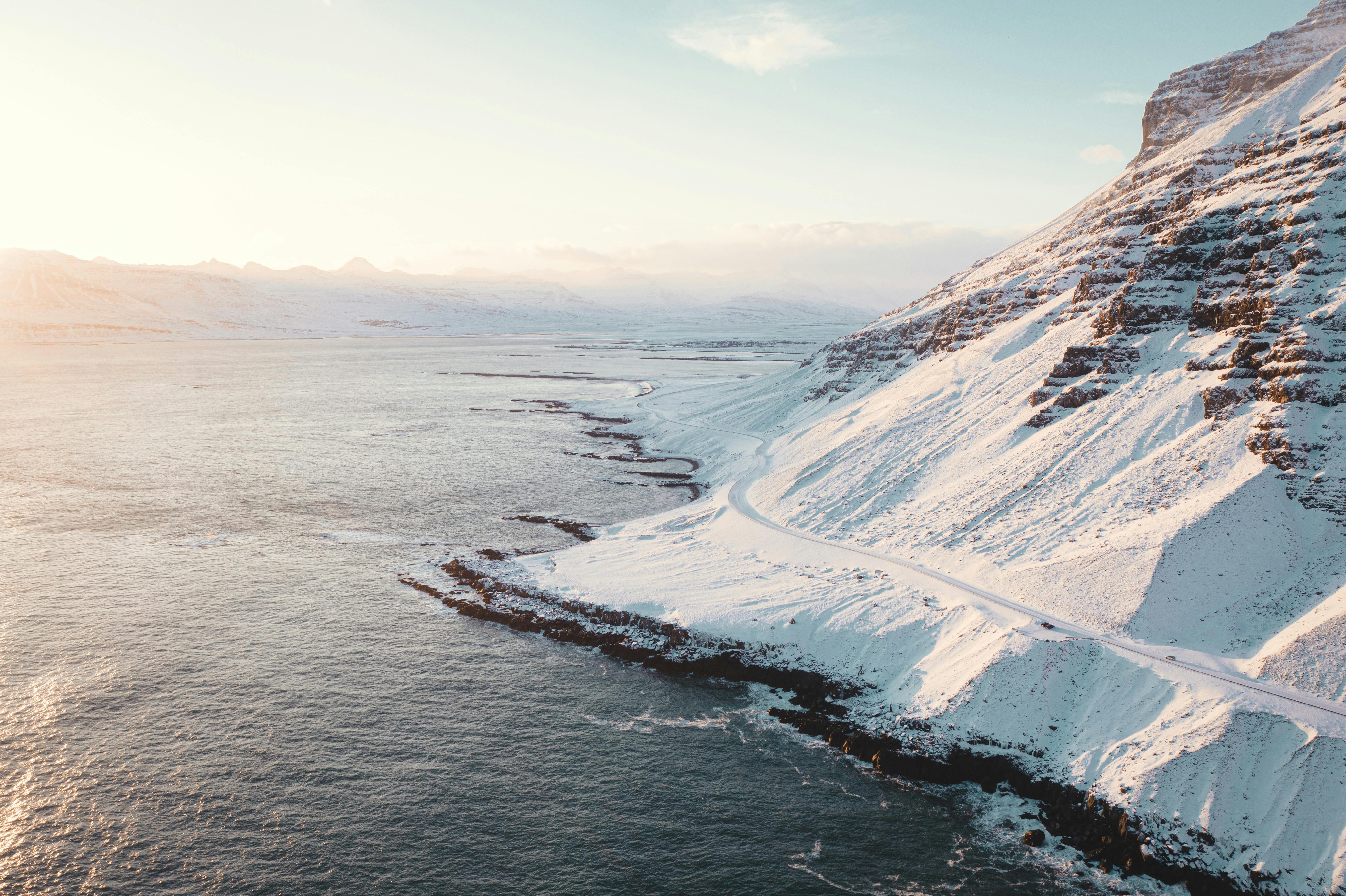 Prescription Goggle Inserts - Stunning aerial view of a snow-covered coastal mountain at sunrise, showcasing the beauty of winter nature.