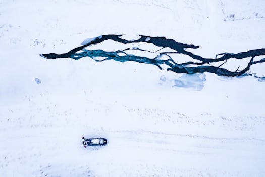 A drone captures a stunning icy river cutting through a snowy expanse.