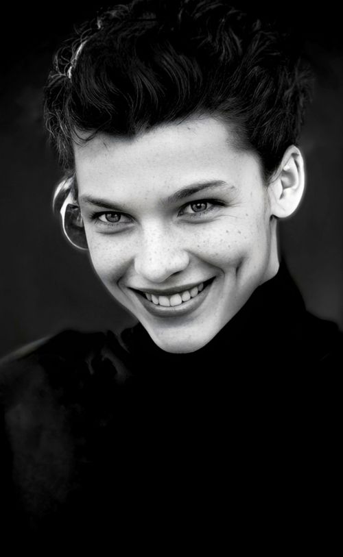 Free Stunning black and white portrait of a woman with short hair and a captivating smile. Stock Photo