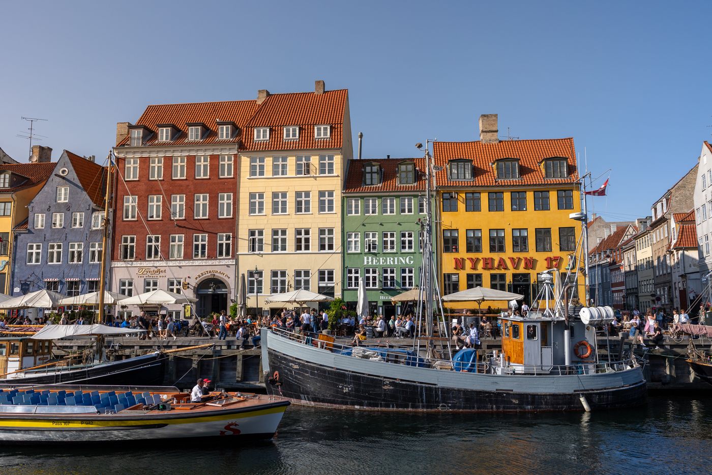 Boats and coloured facades along Nyhavn harbour in Copenhagen