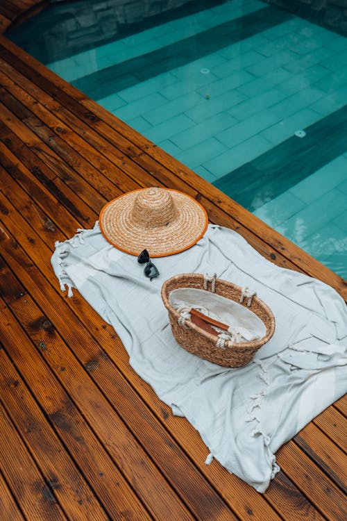 Hat and Basket on Fabric near Swimming Pool