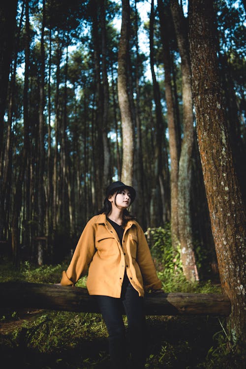 Woman in Hat and Jacket Posing in Forest