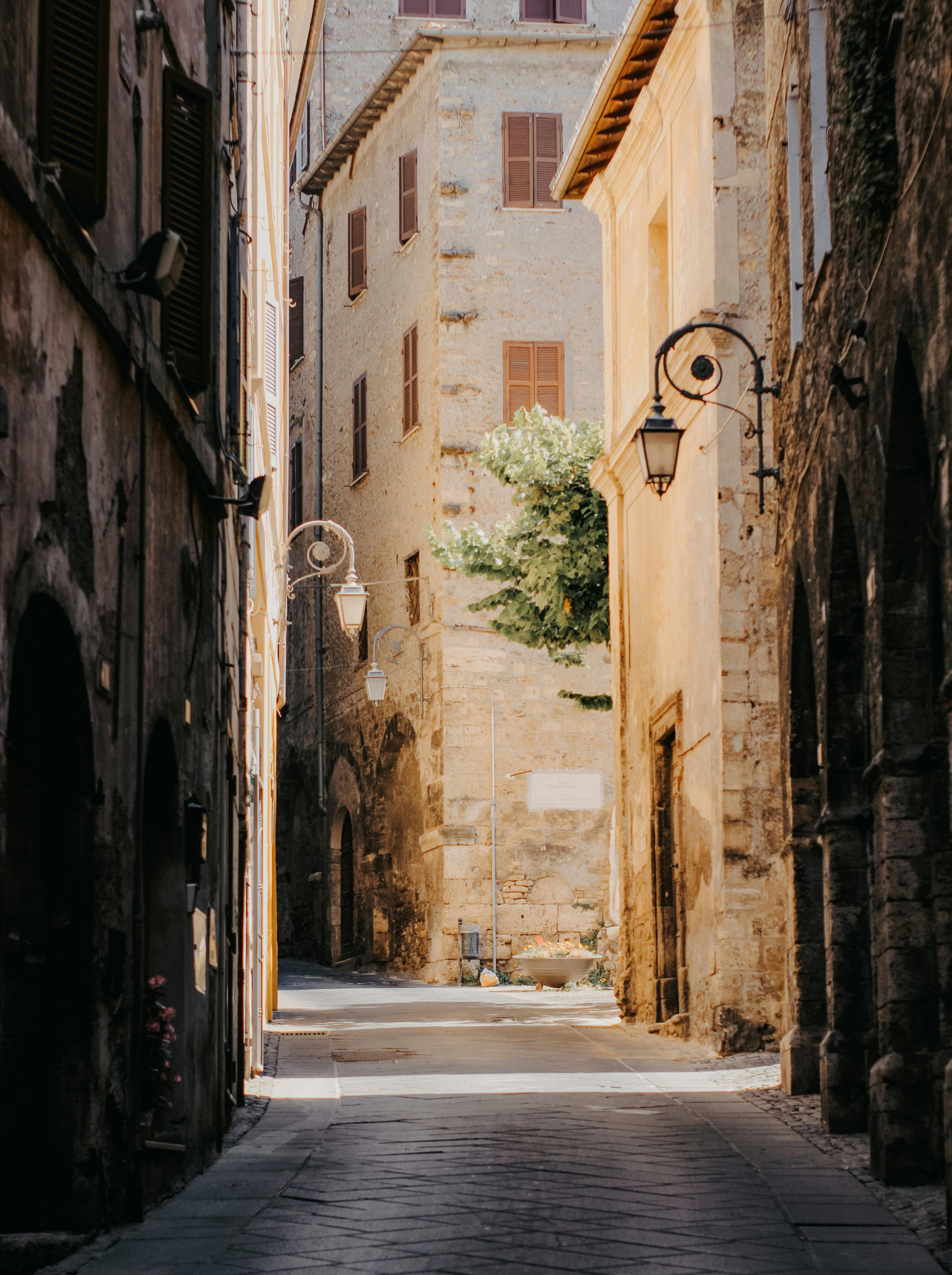 A tranquil alleyway in an old European town bathed in soft sunlight, creating a nostalgic ambiance.