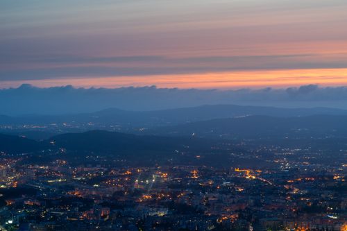 Free Stunning aerial view of Braga, Portugal, with city lights and colorful twilight sky. Stock Photo