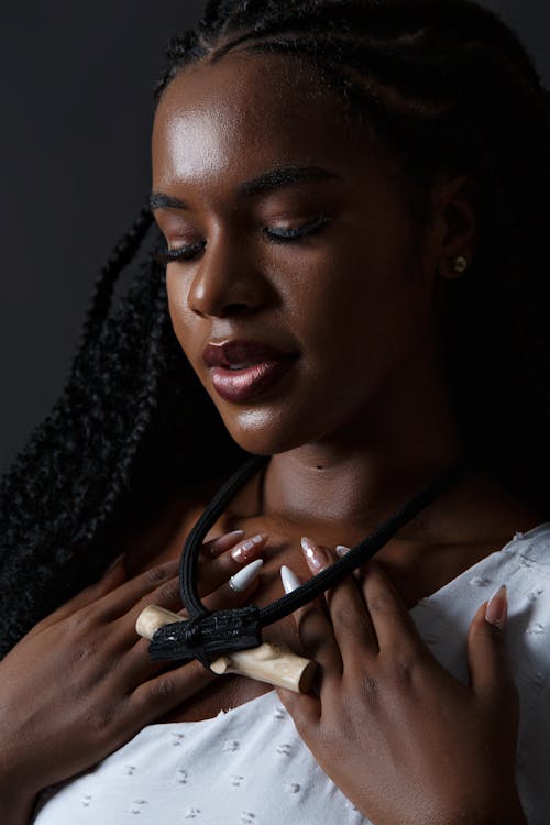 Studio Shot of a Young Woman Wearing a Necklace with a Piece of Wood 