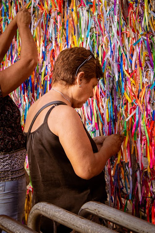 Elderly Woman Standing in Front of Wall with Colorful Bracelets