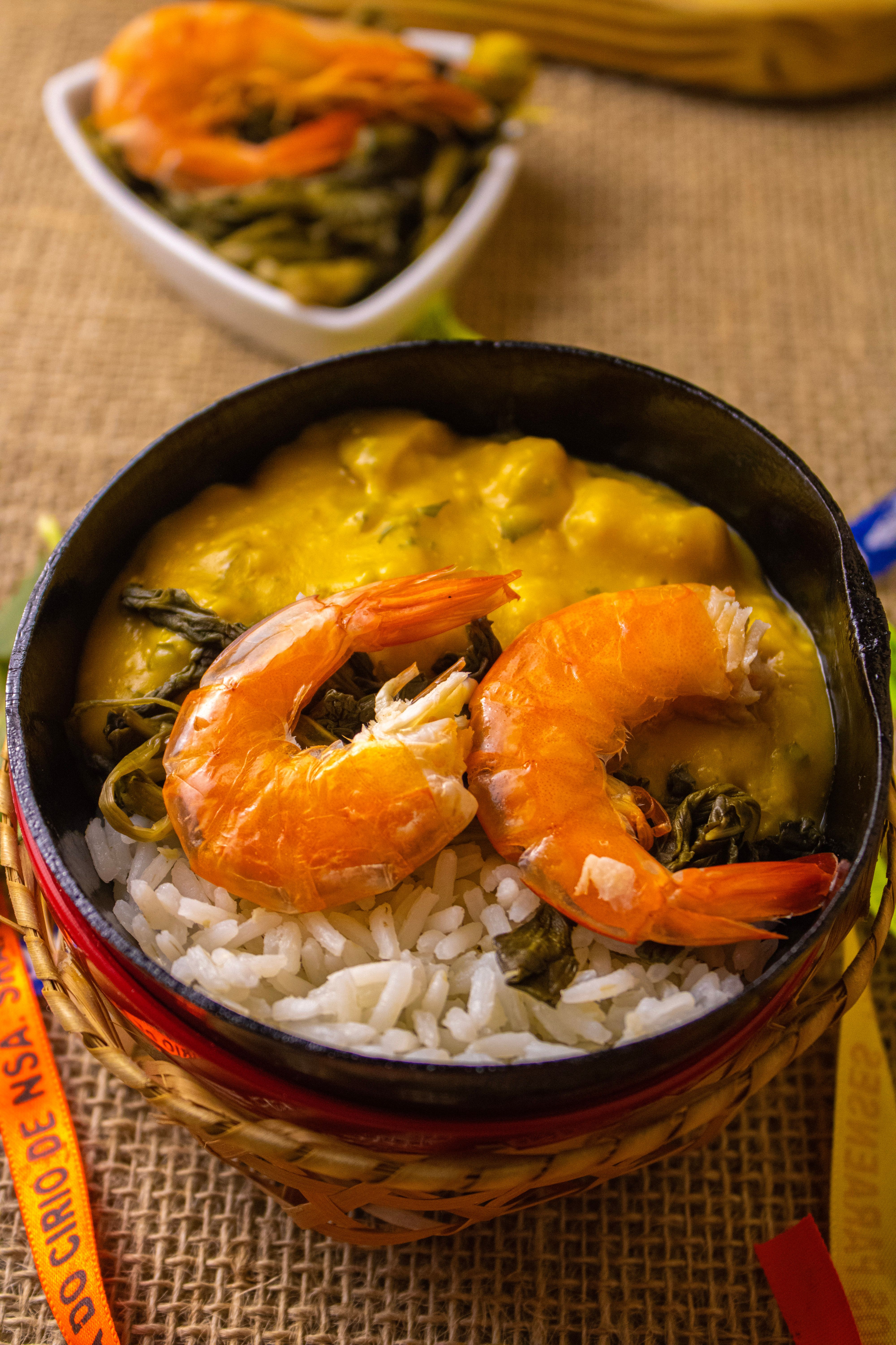 Savor this appetizing shrimp dish featuring rice and vibrant greens in a rustic setting.