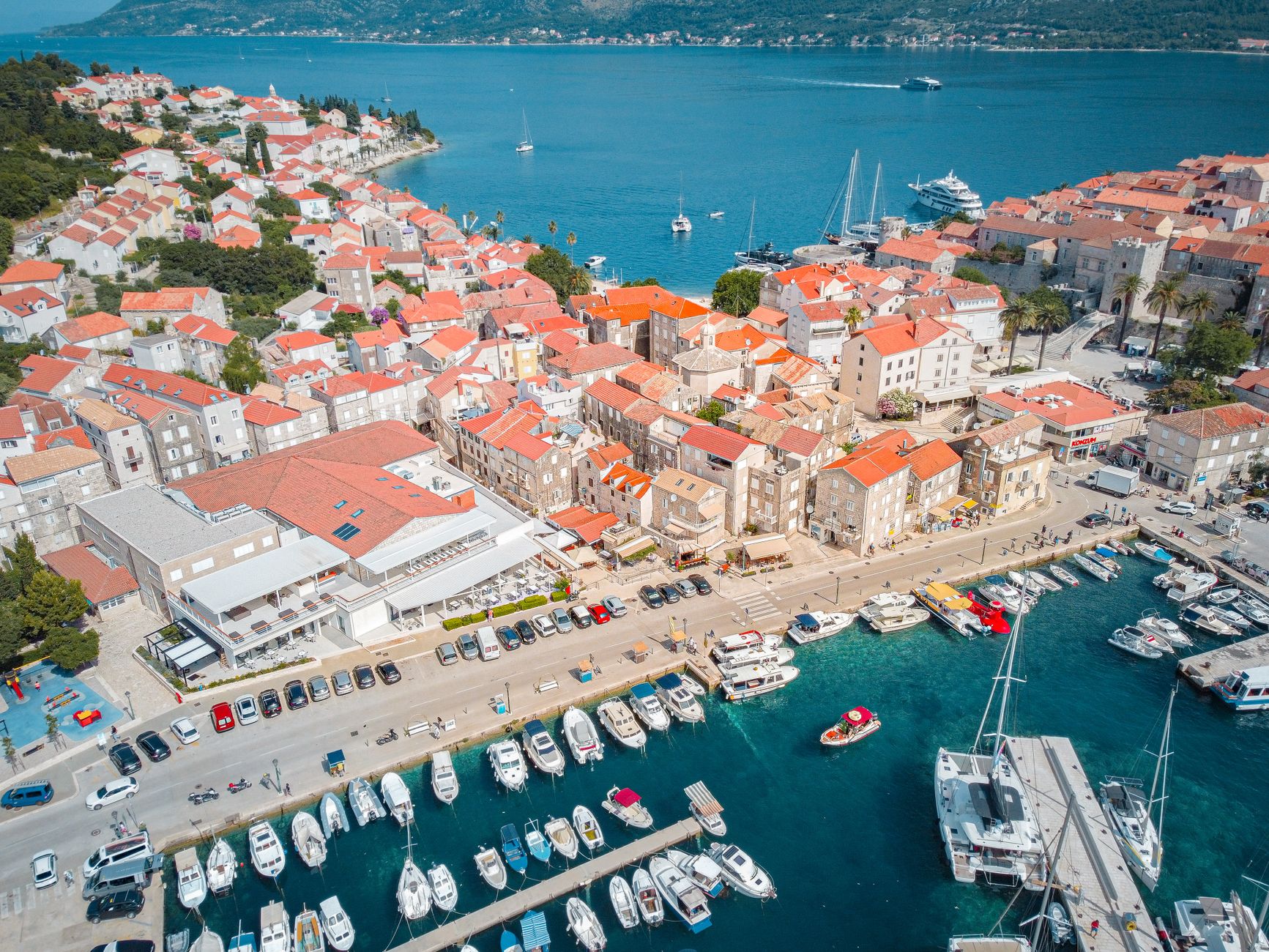 A stunning aerial view of Korcula's old town and marina with vibrant blue sea.