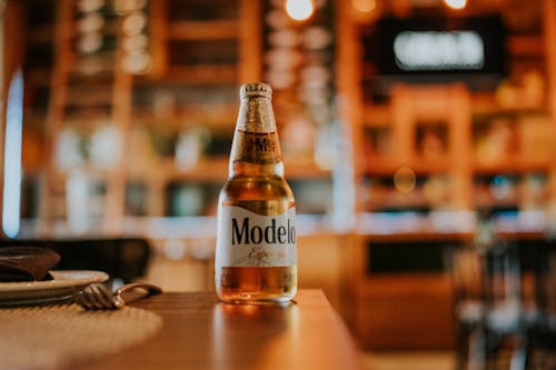 Close-up of a Bottle of Cold Beer Standing on a Table in a Restaurant 