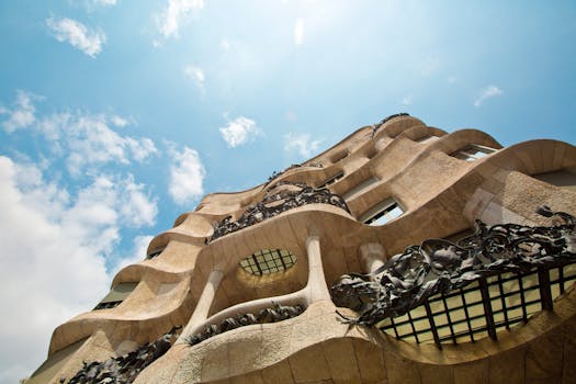 Low angle view of the Casa Milà's unique architectural facade against a vibrant sky. by tyler hendy