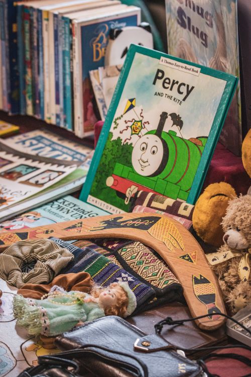 Free Assorted secondhand market stall items including books, toys, and crafts. Stock Photo
