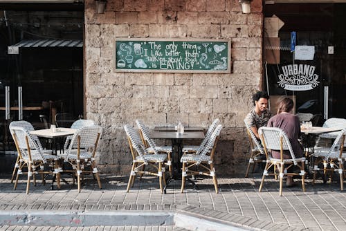 Cafe Seats on a Street by a Stone Wall