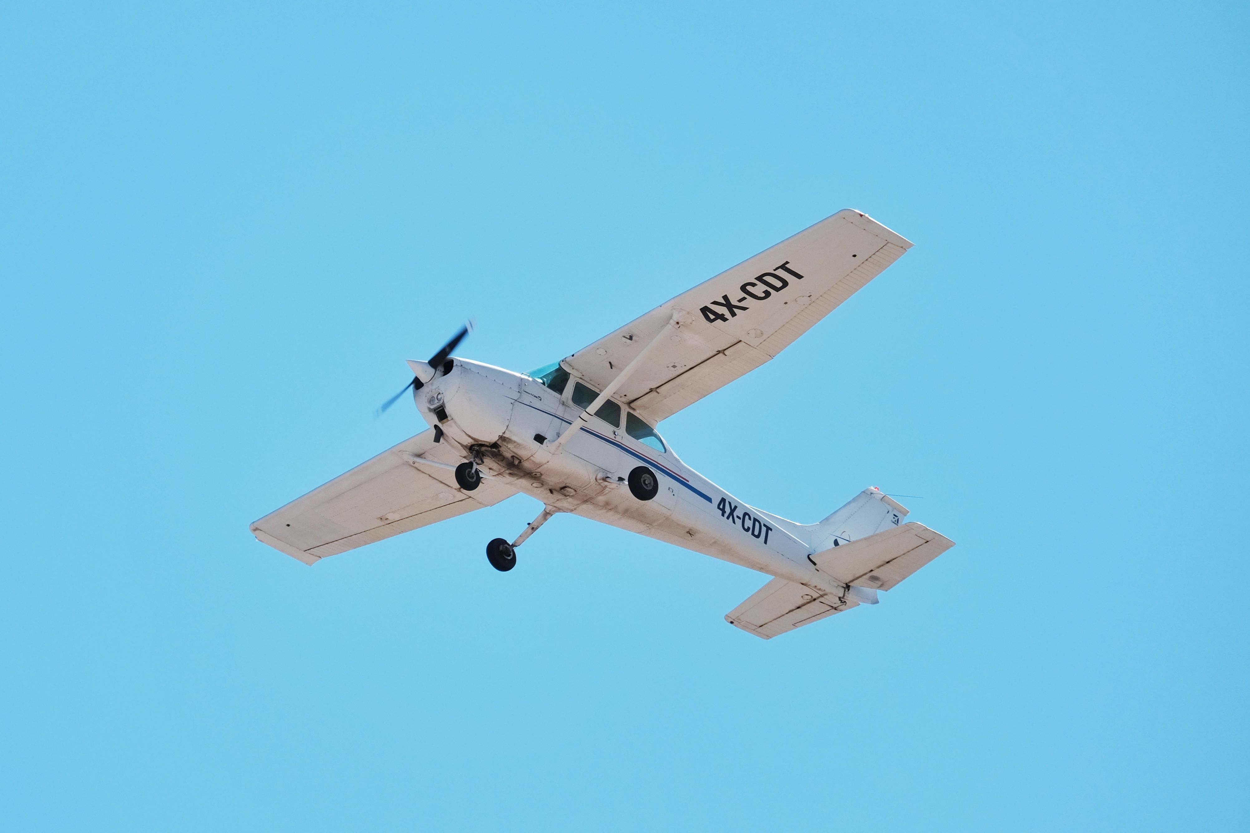 An Airplane Flying against Clear Blue Sky · Free Stock Photo