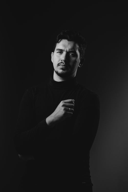 Free Dramatic black and white portrait of a man in a studio setting, exuding a thoughtful mood. Stock Photo