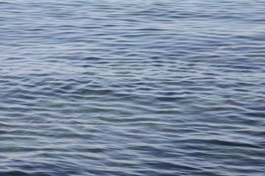 Serene ocean surface with soft, wavy patterns in natural light.