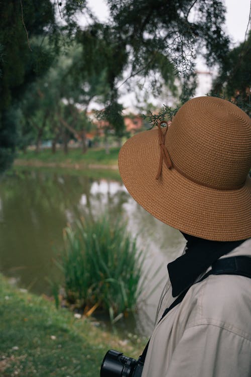 Person in Wide Hat Standing on River Shore