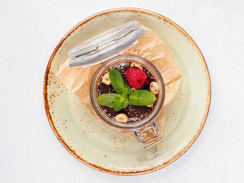 Free Indulge in a delectable gourmet chocolate dessert topped with fresh mint and raspberry in a stylish glass jar. Stock Photo