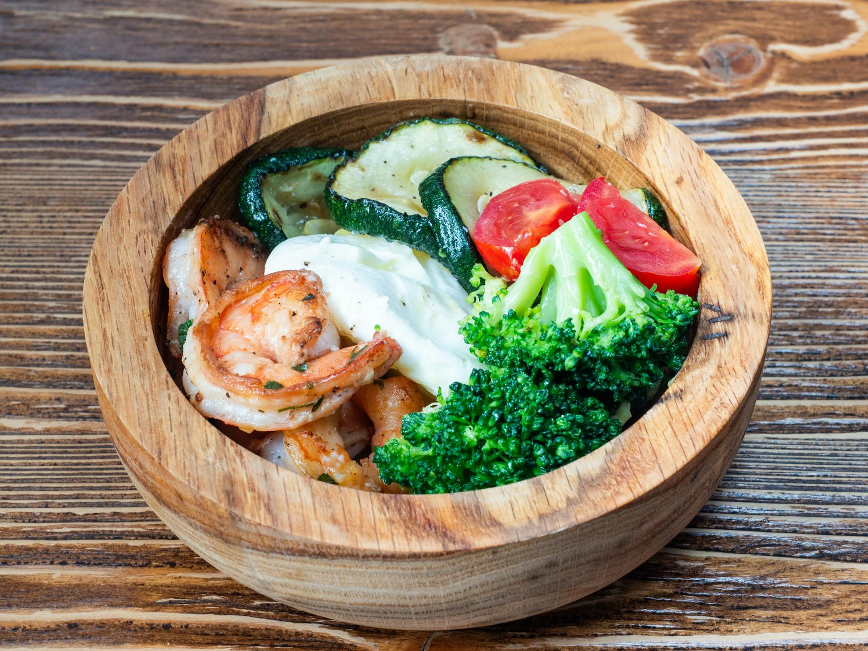 Shrimp And Grits In A Bowl, Garnished With Herbs, Served On A Rustic Wooden Table