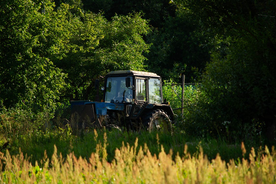 A Tractor Parked on a Grass Field 