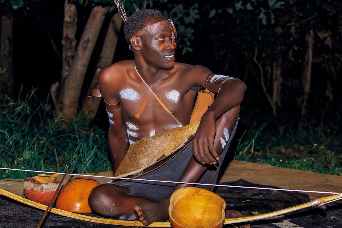 A Man with Tribal Body Painting Sitting on the Ground at Night