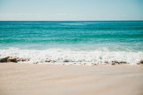 Free Bright sunny day at Gold Coast beach with gentle waves and clear blue ocean. Stock Photo