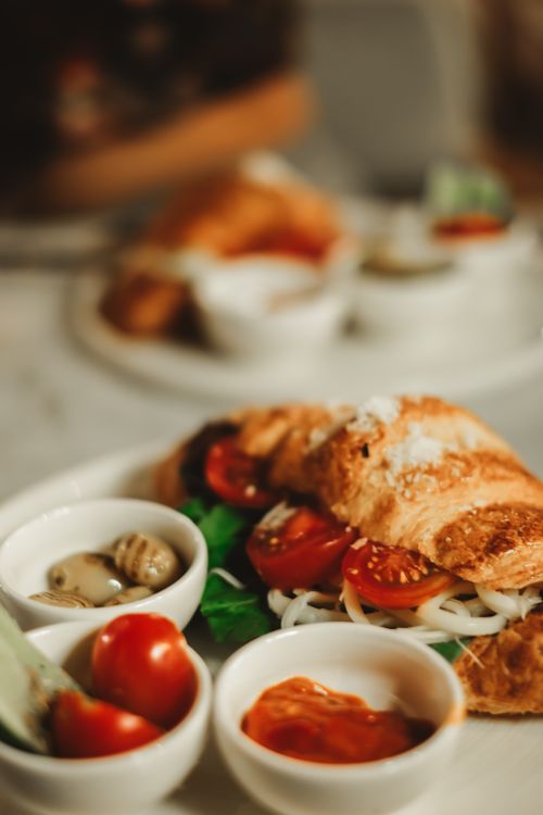 Free Close-up of a croissant sandwich filled with fresh vegetables, perfect for breakfast or lunch. Stock Photo