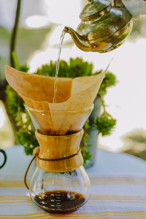 Person Pouring Hot Water in a Chemex Coffee Jar with Paper Filter