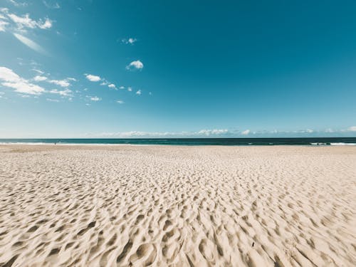 Foto profissional grátis de areia, céu azul, céu limpo