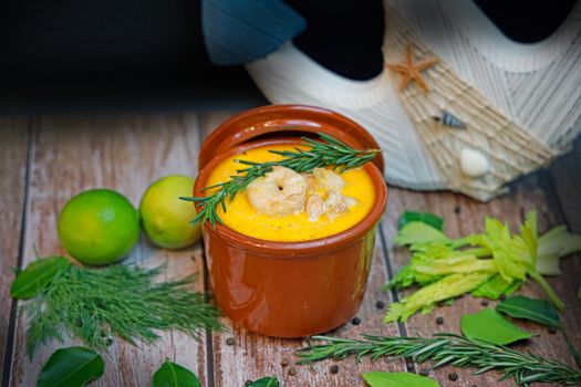 Delicious seafood soup with shrimp, rosemary, and lime garnish in a rustic setting.