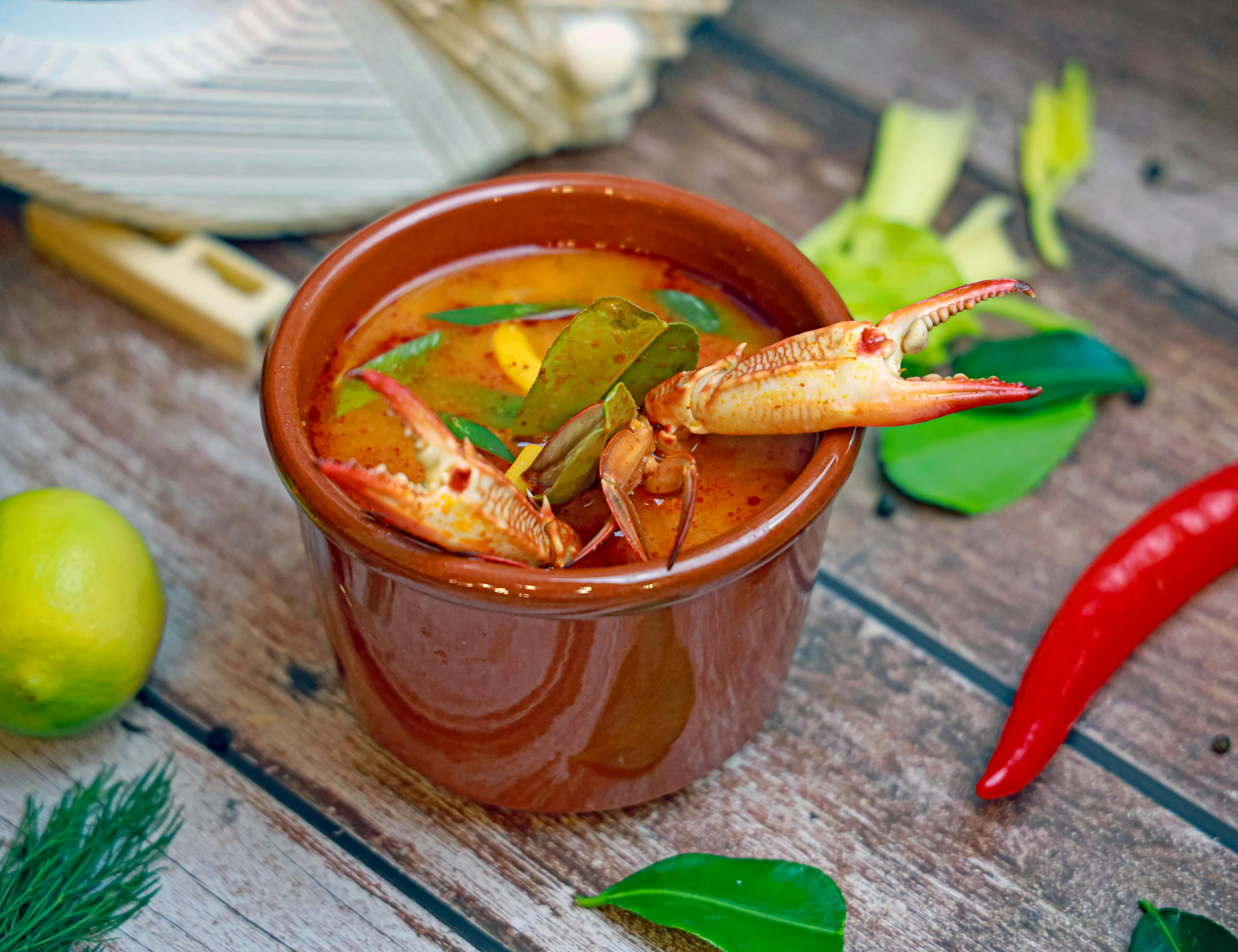 a bowl of soup with shrimp and vegetables