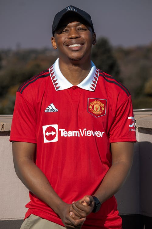 Young Man in a Football Shirt and a Baseball Cap 