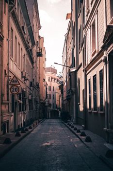 A serene urban alleyway with towering architectural facades in warm afternoon light.