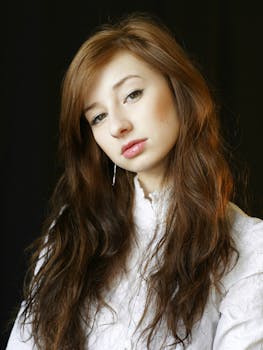 Elegant portrait of a young woman with long brown hair in a studio setting.