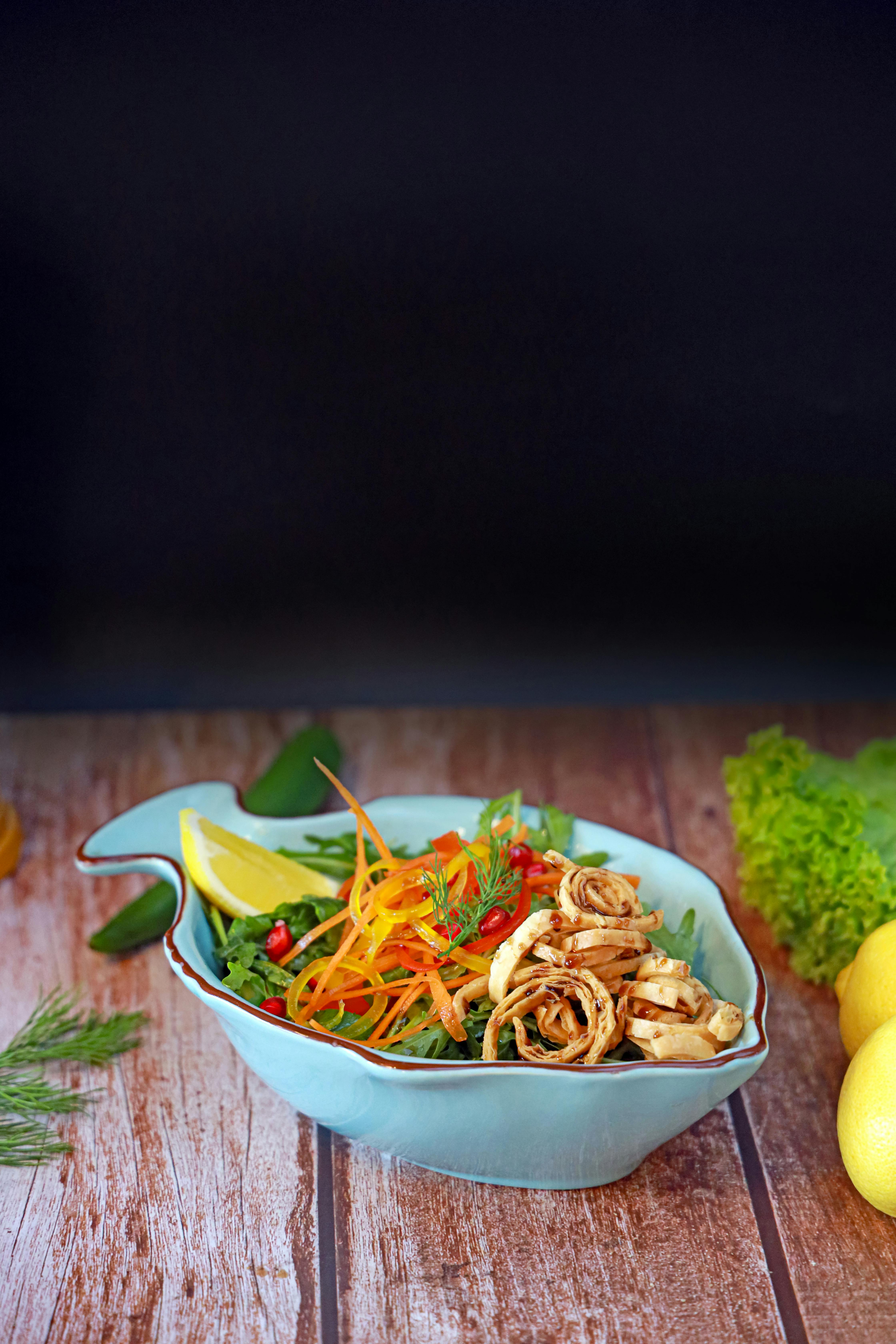 A bowl of noodles with vegetables and lemon