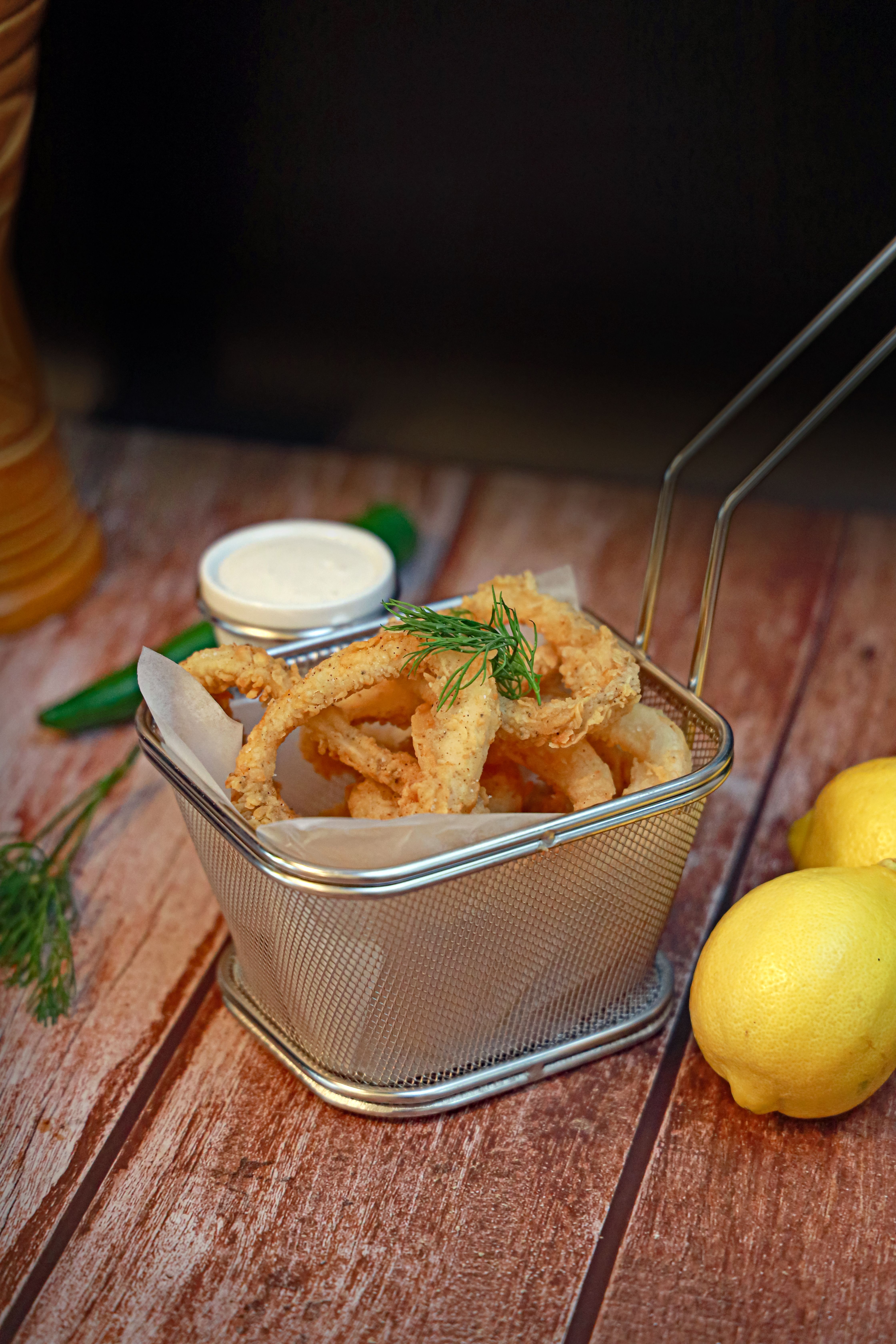 Golden fried calamari rings served with dipping sauce and fresh lemons.