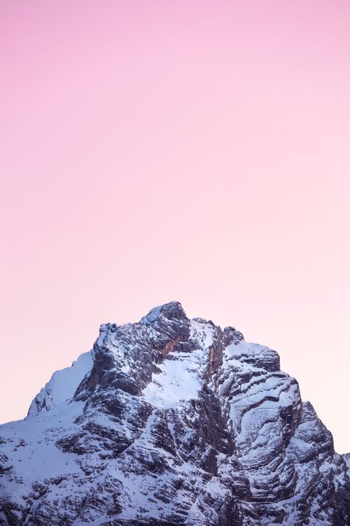 Free Captivating view of a snow-covered mountain peak under a pink sunset sky. Stock Photo