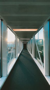 Sunlit modern glass corridor in Ankara, showcasing architectural elegance and symmetry.
