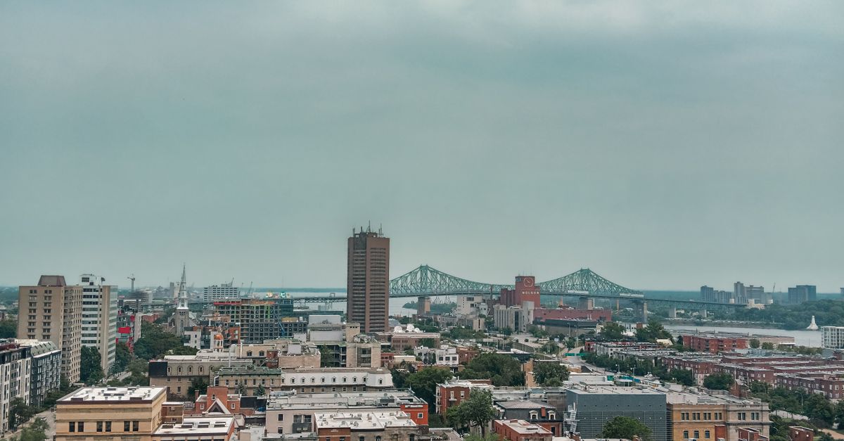 Stunning aerial view of Montréal's urban landscape featuring a prominent bridge under a cloudy sky.